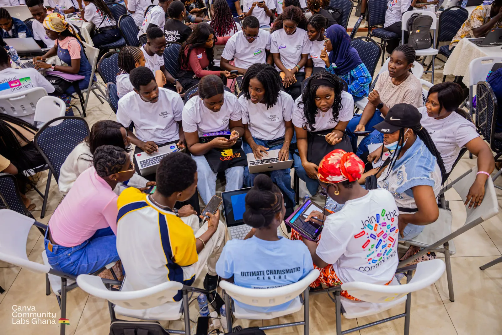 A team of attendees pulled into a tight circle of chairs, heads together over two laptops and a tablet.